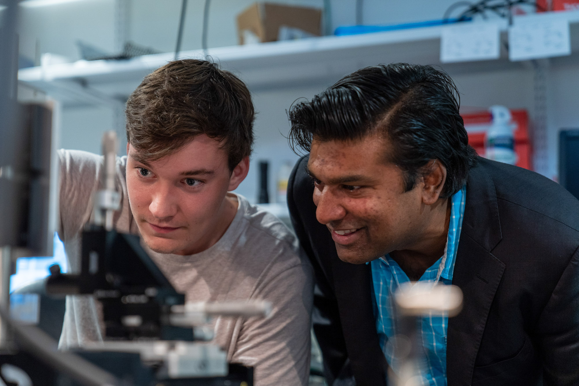 Professor Steve Adie watches as a student researcher conducts an experiment in the Adie lab