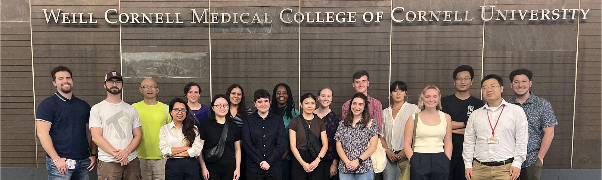 Students and faculty stand below Weill Cornell Medical College sign in New York City