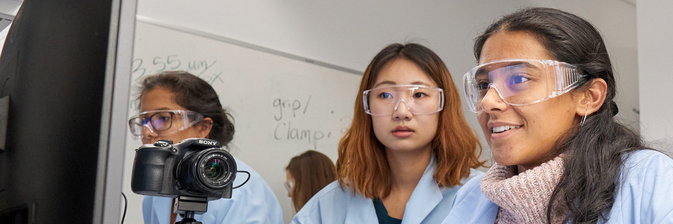 Students work together around a computer