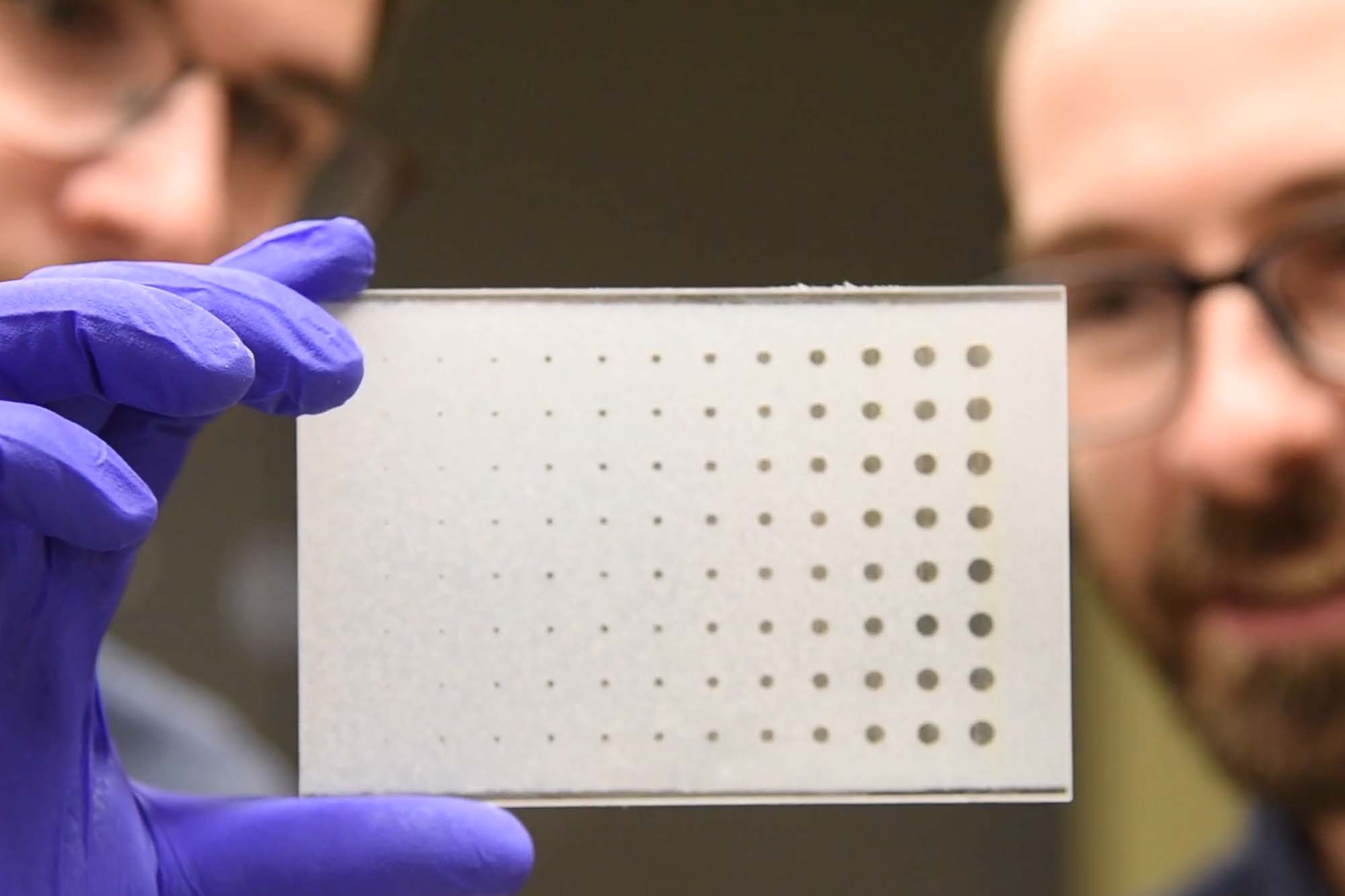 Jon Albo and Nate Cira hold up the spots liquid handling plate they developed