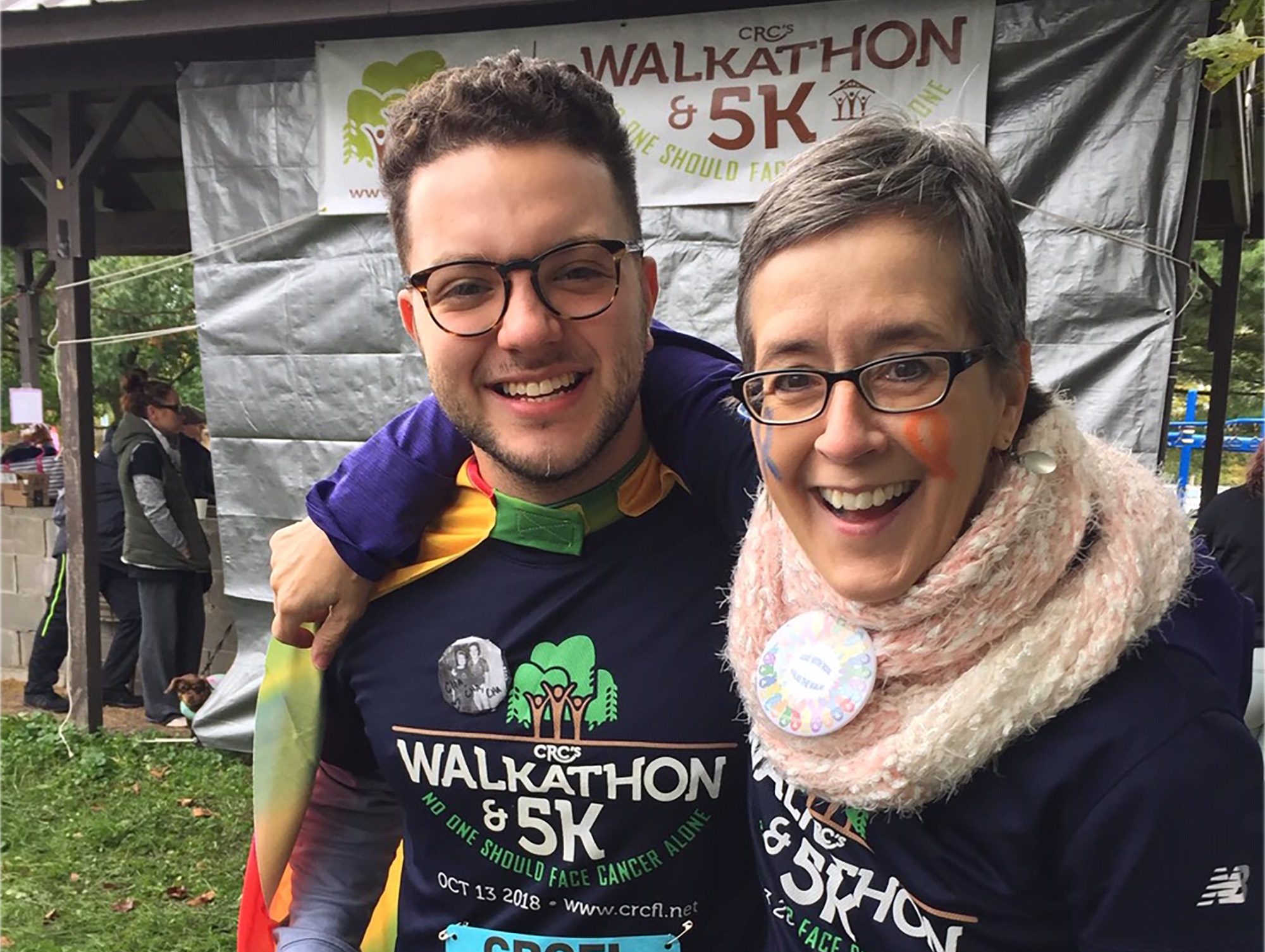 Graduate student and cancer survivor embrace at community 5k walkathon.