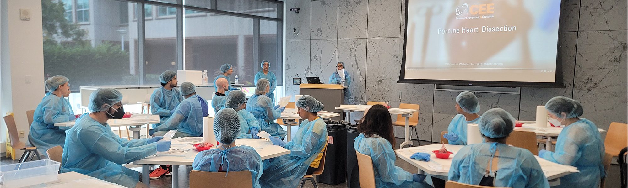 Students wearing scrubs in classroom for cardiac electrophysiology pig heart dissection
