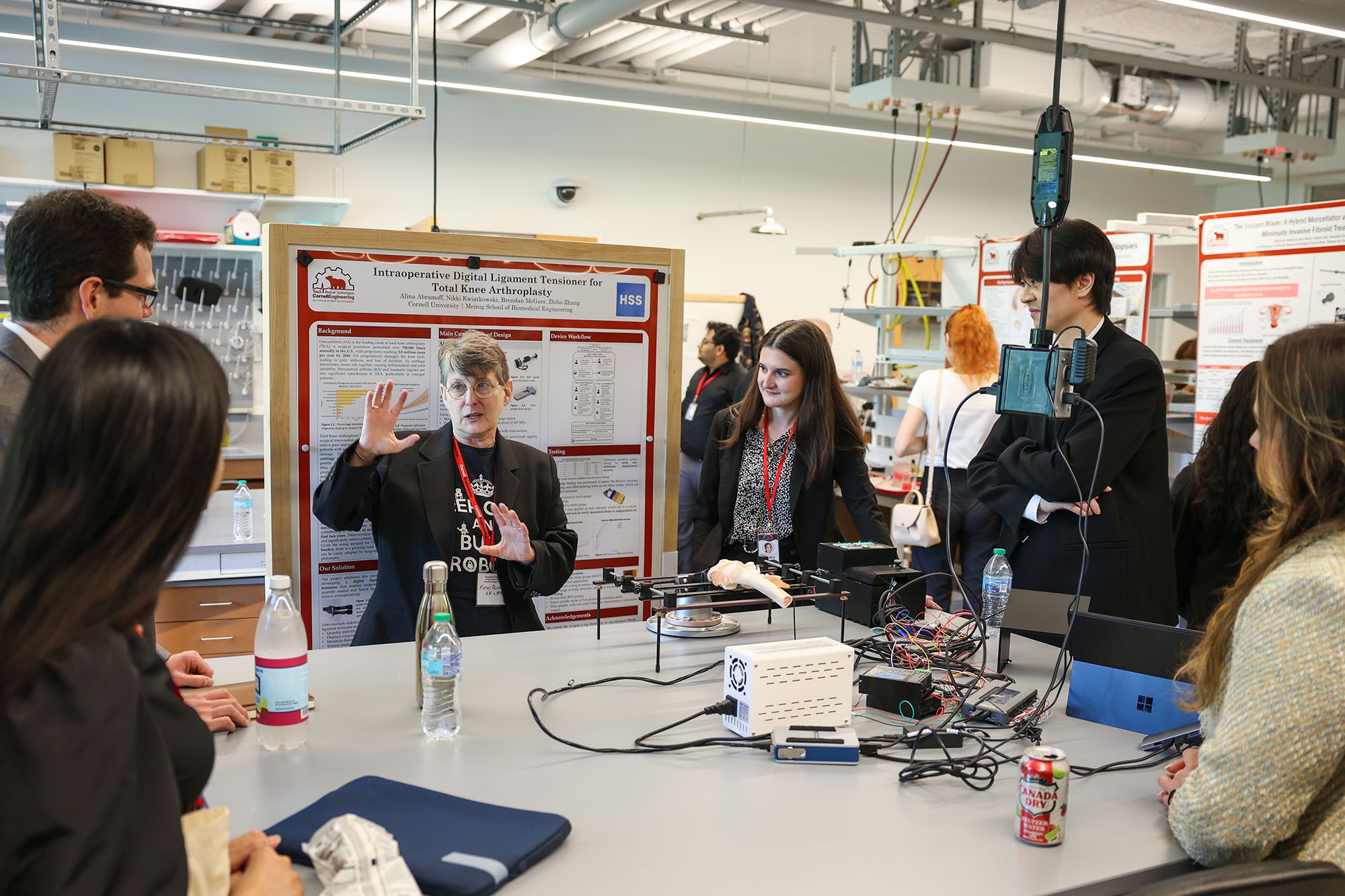 MEng students talk with industry professionals standing at lab benches at Industry Day 2025 in Tang Hall design lab.