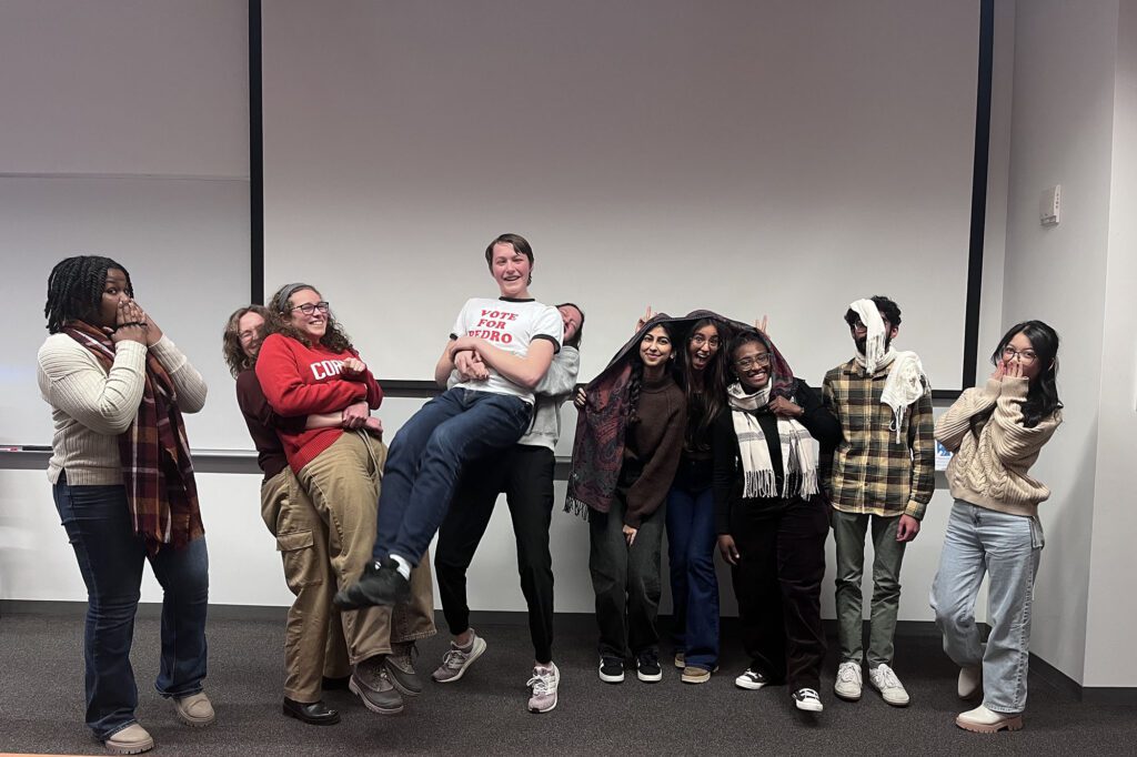 BMES graduate student group leadership stands together making silly faces in a Weill Hall classroom.