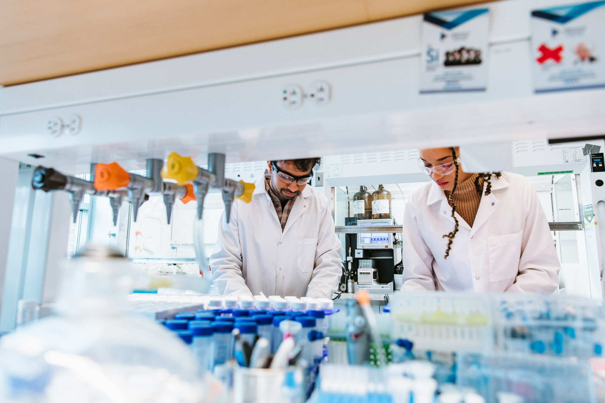 two researchers in lab coats conducting an experiment in the Alabi Lab.