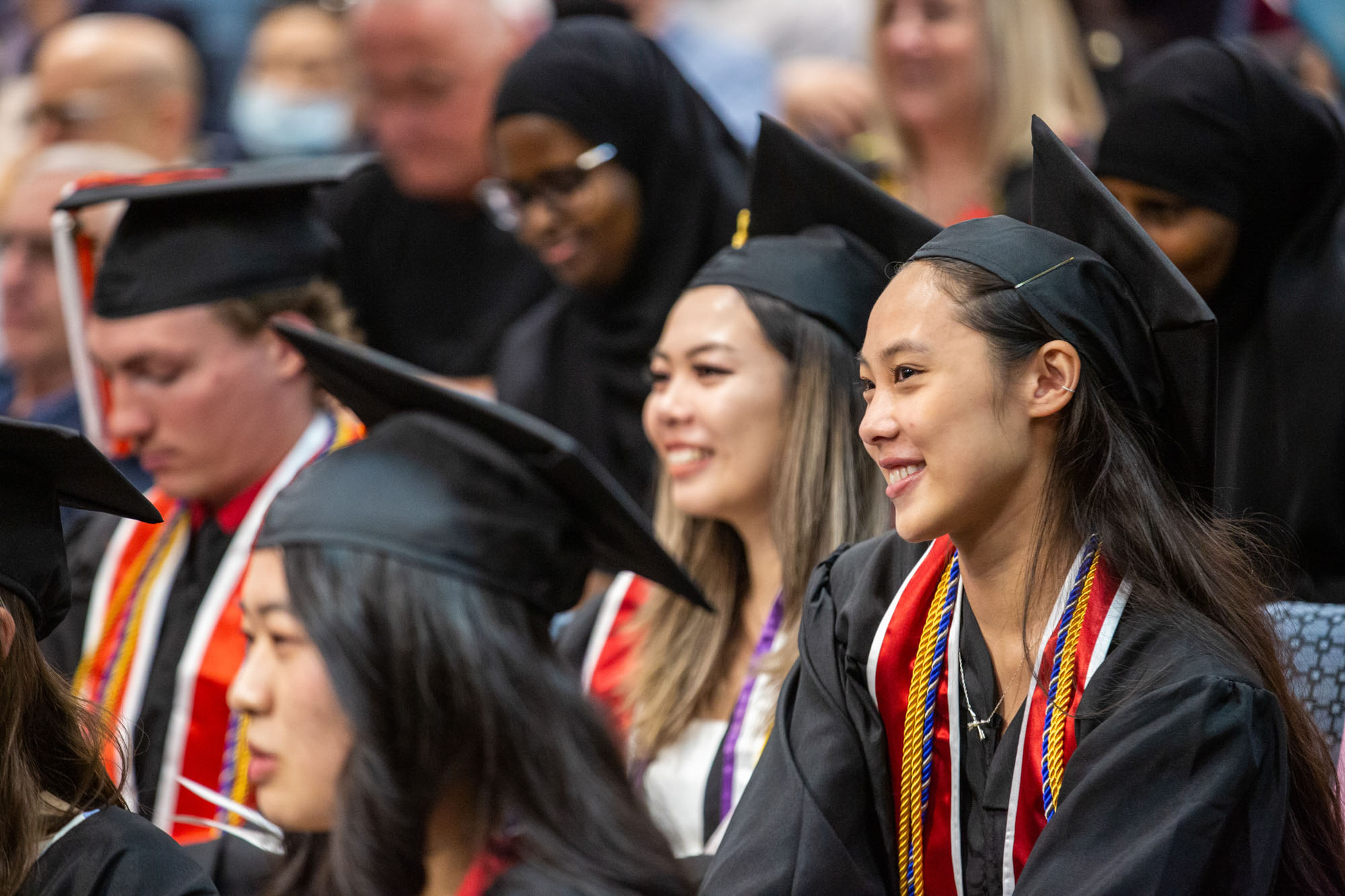 a group of students in cap and gown smiling at commencement