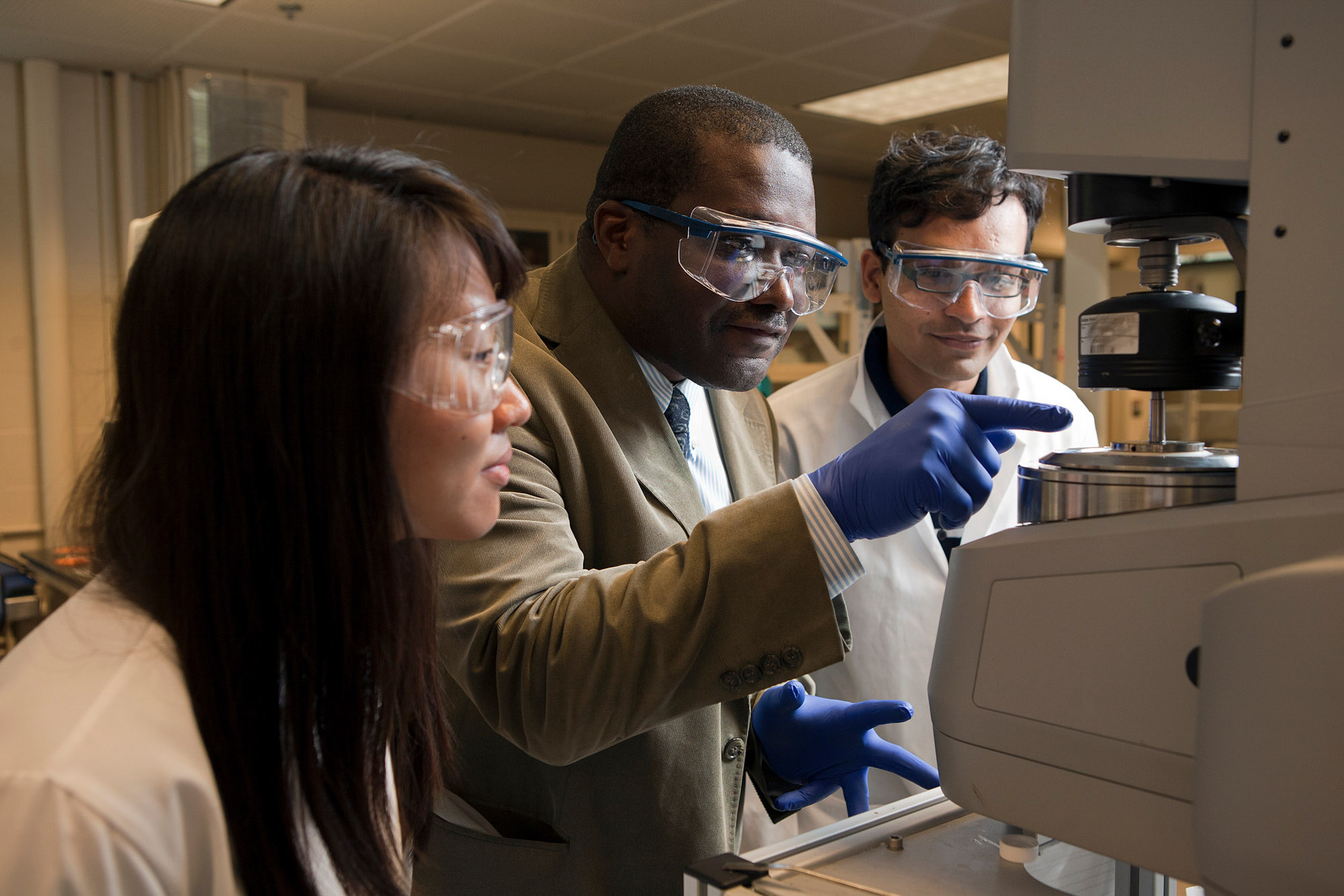 Dean Lynden Archer and two students working in the Kaust Center in Kimball Hall.