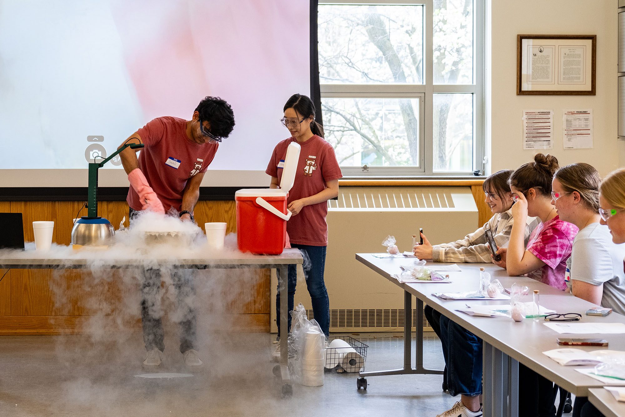 Graduate students present dry ice experiment to kids