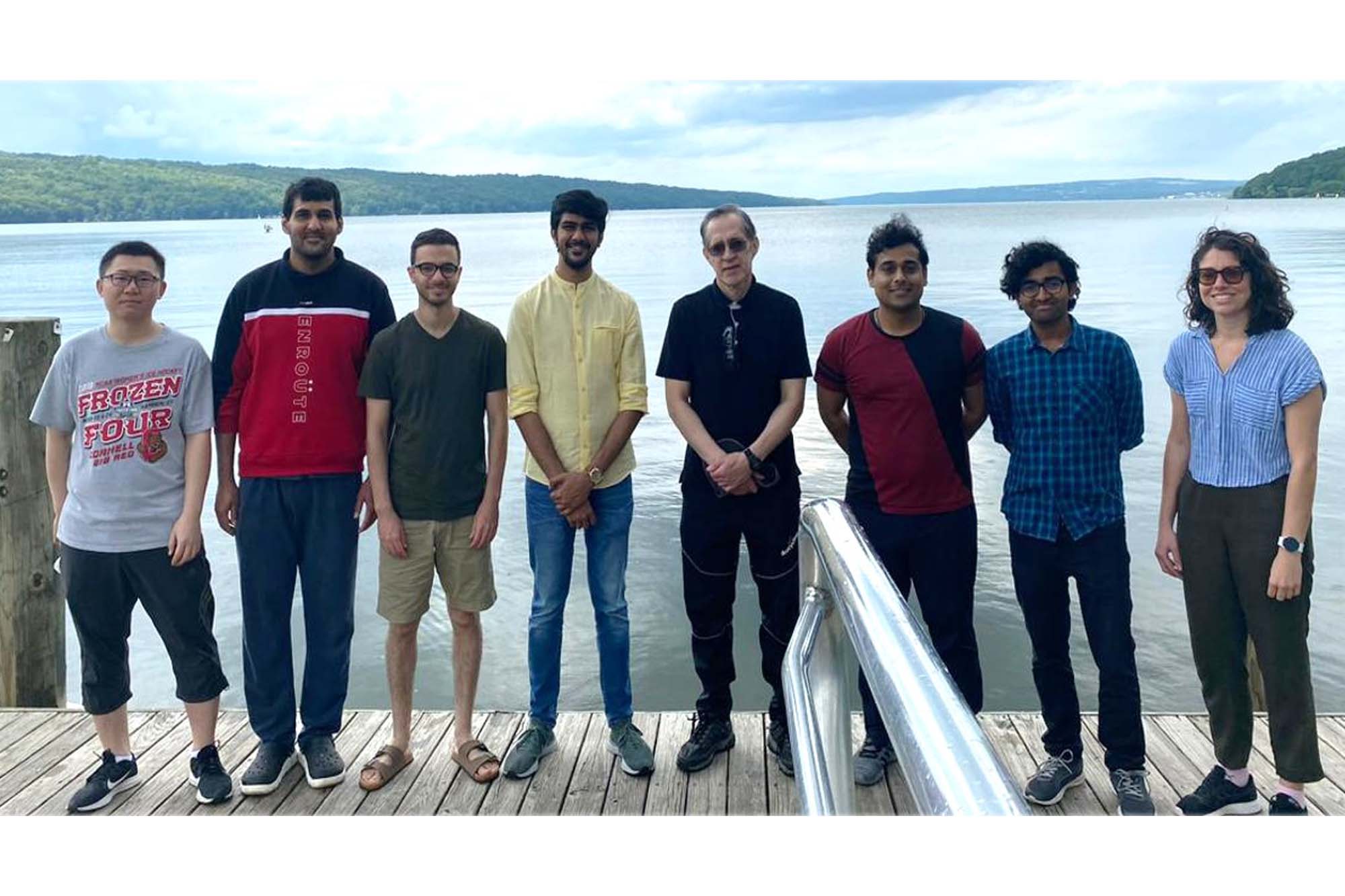 Escobedo lab stands on dock with Cayuga Lake behind them.