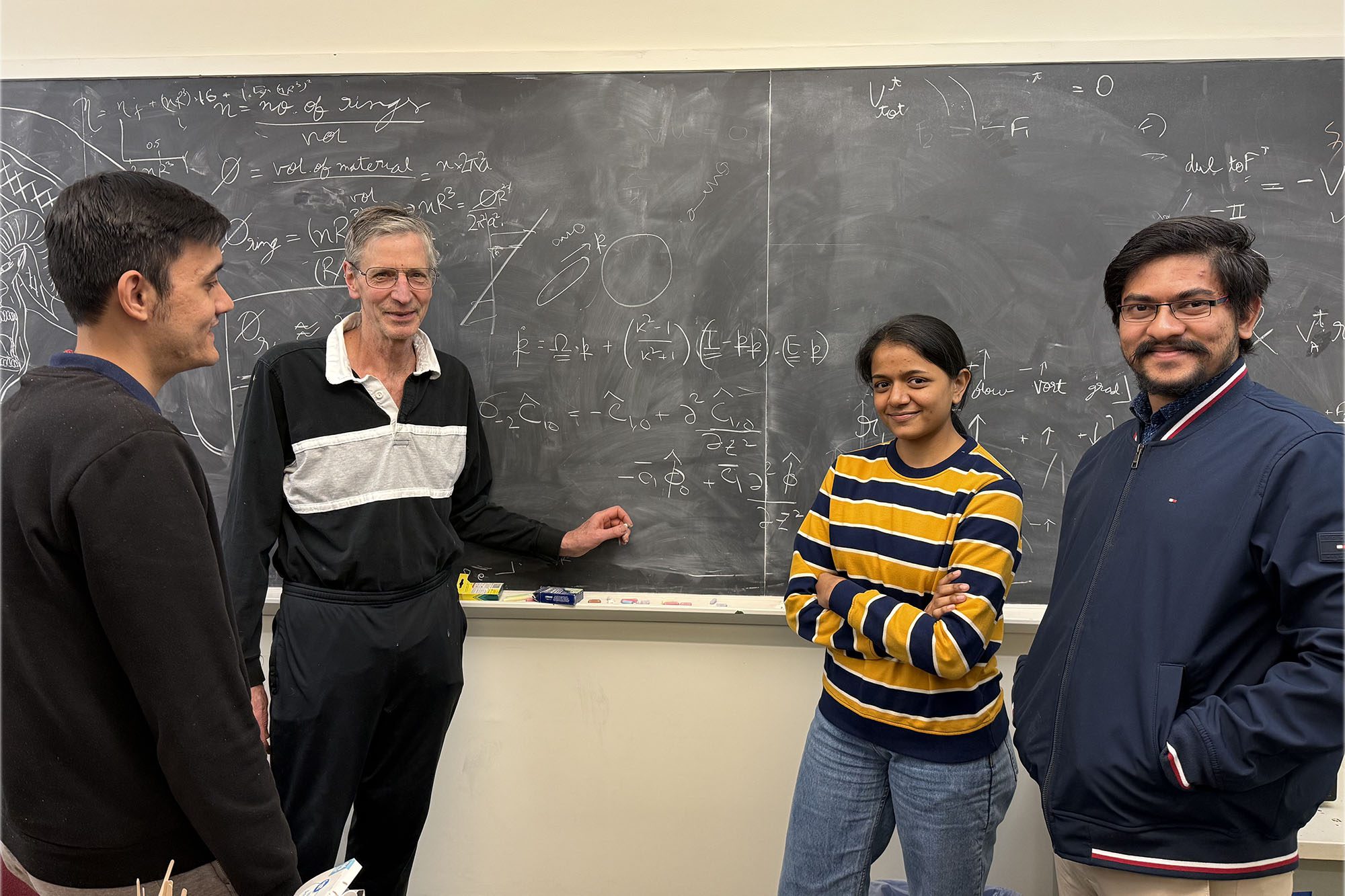 Donald Koch with students at the blackboard.
