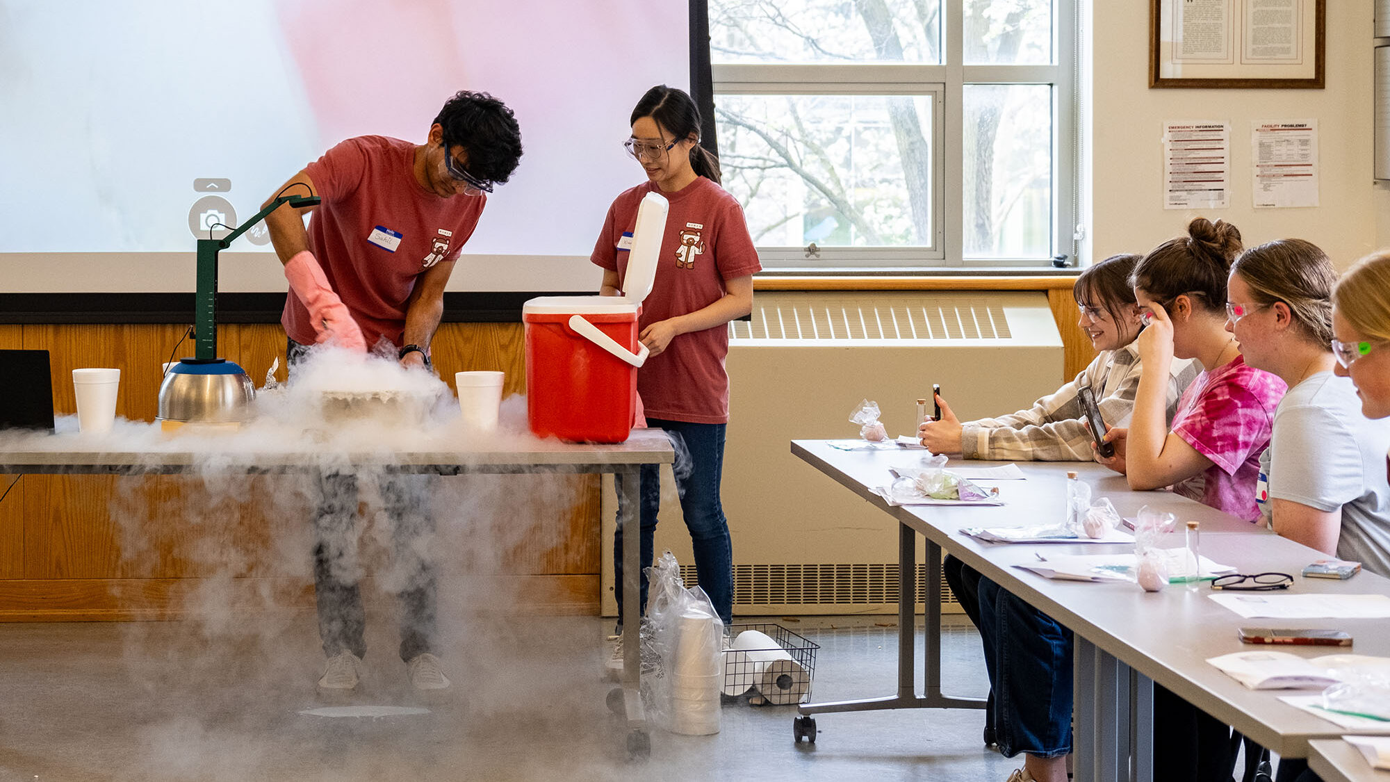 Graduate students present experiment to kids using dry ice.