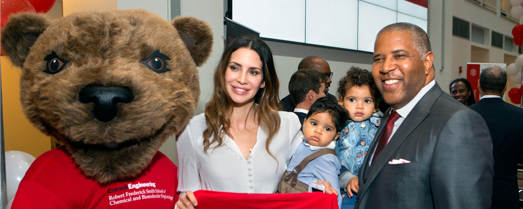 Robert F. Smith stands with Cornell's Touchdown bear mascot and attendees at 2016 dedication event in Duffield Hall atrium.