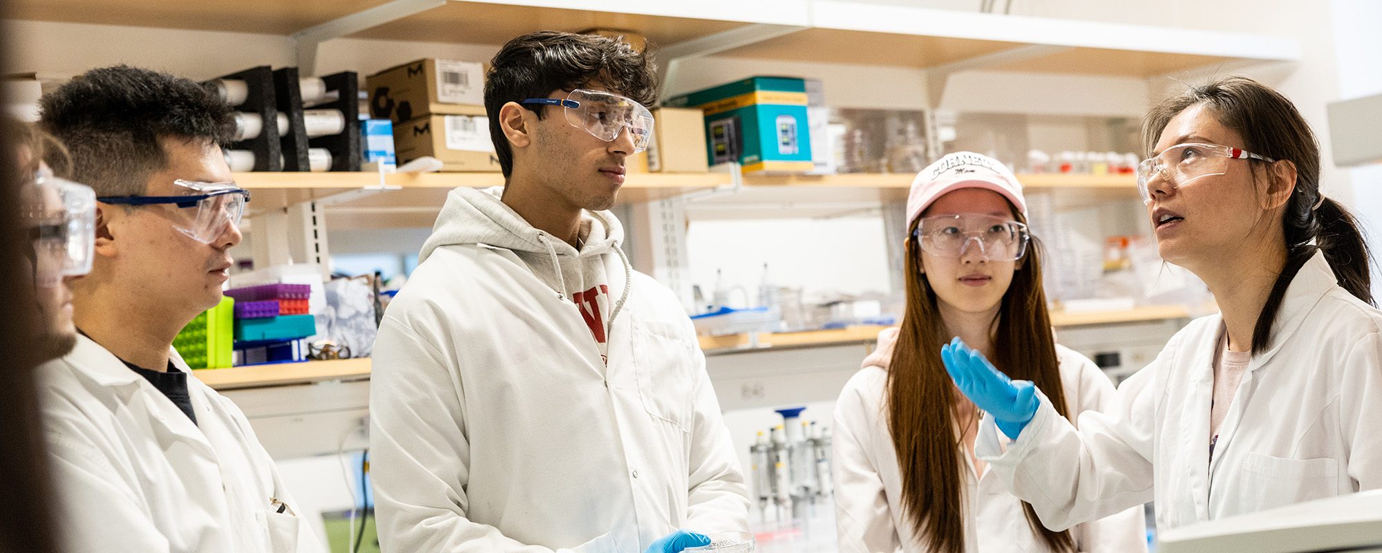Rong Wang with MEng student in lab coats in Olin Hall Lab.