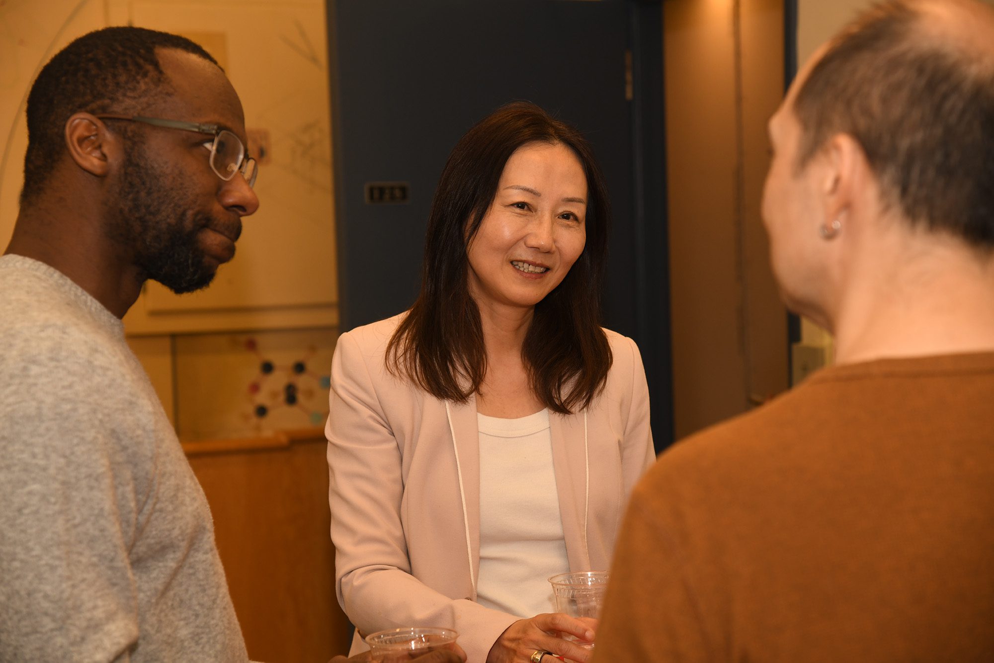 Zhenan Bao talks with Chris Alabi and James Tanaka in Olin Hall lecture room.