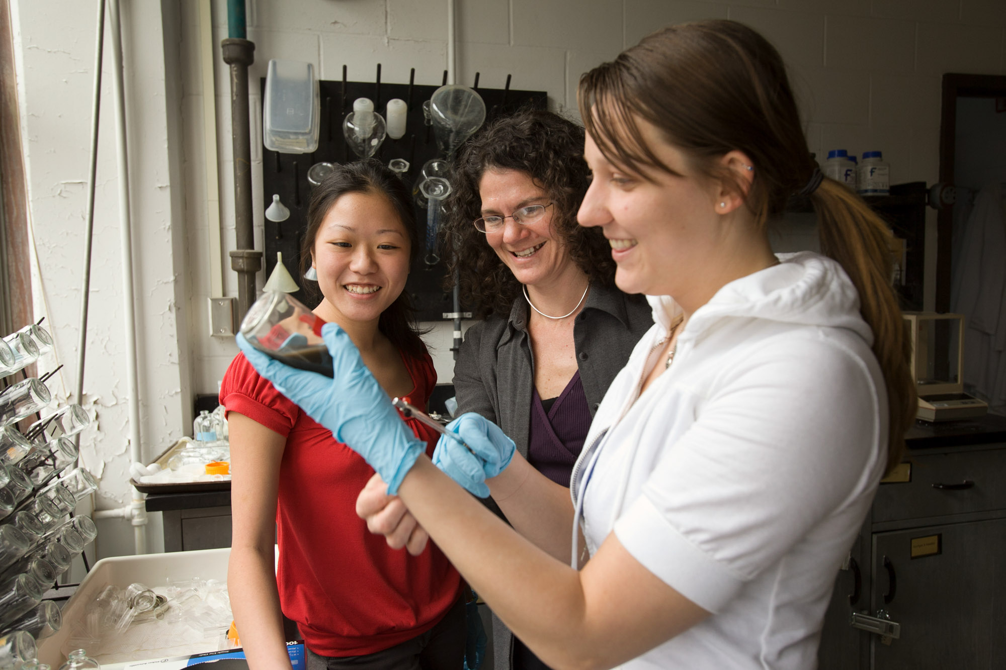 Professor Ruth Richardson watching two students conducting an experiment in the Richardson lab