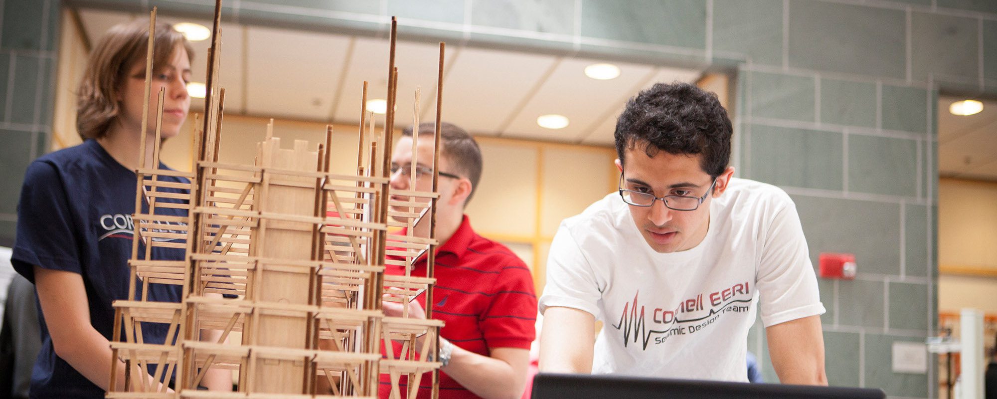 student examines a model tower structure