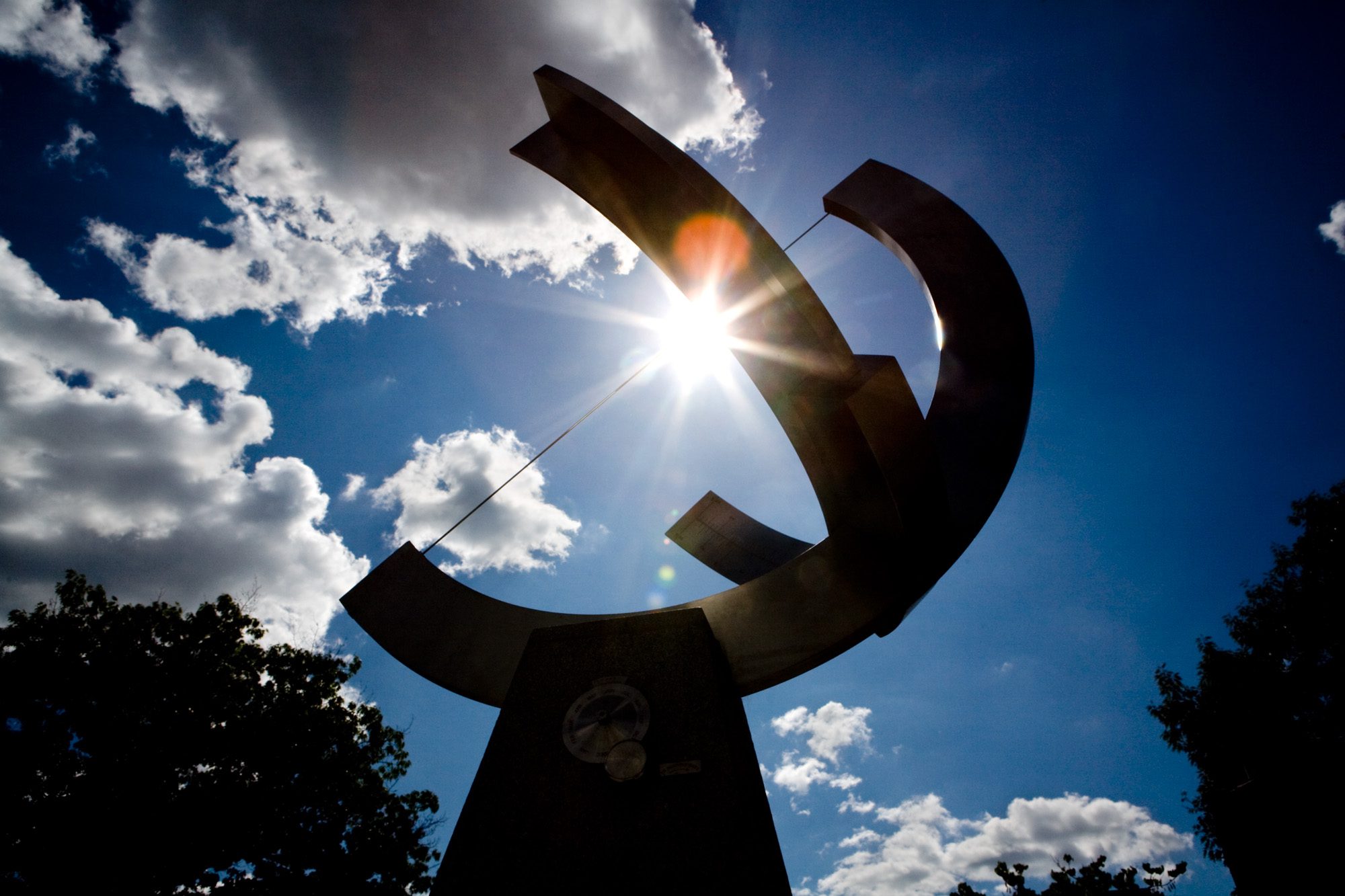 The sun shines behind the Pew Sundial on the Engineering Quad in summer.