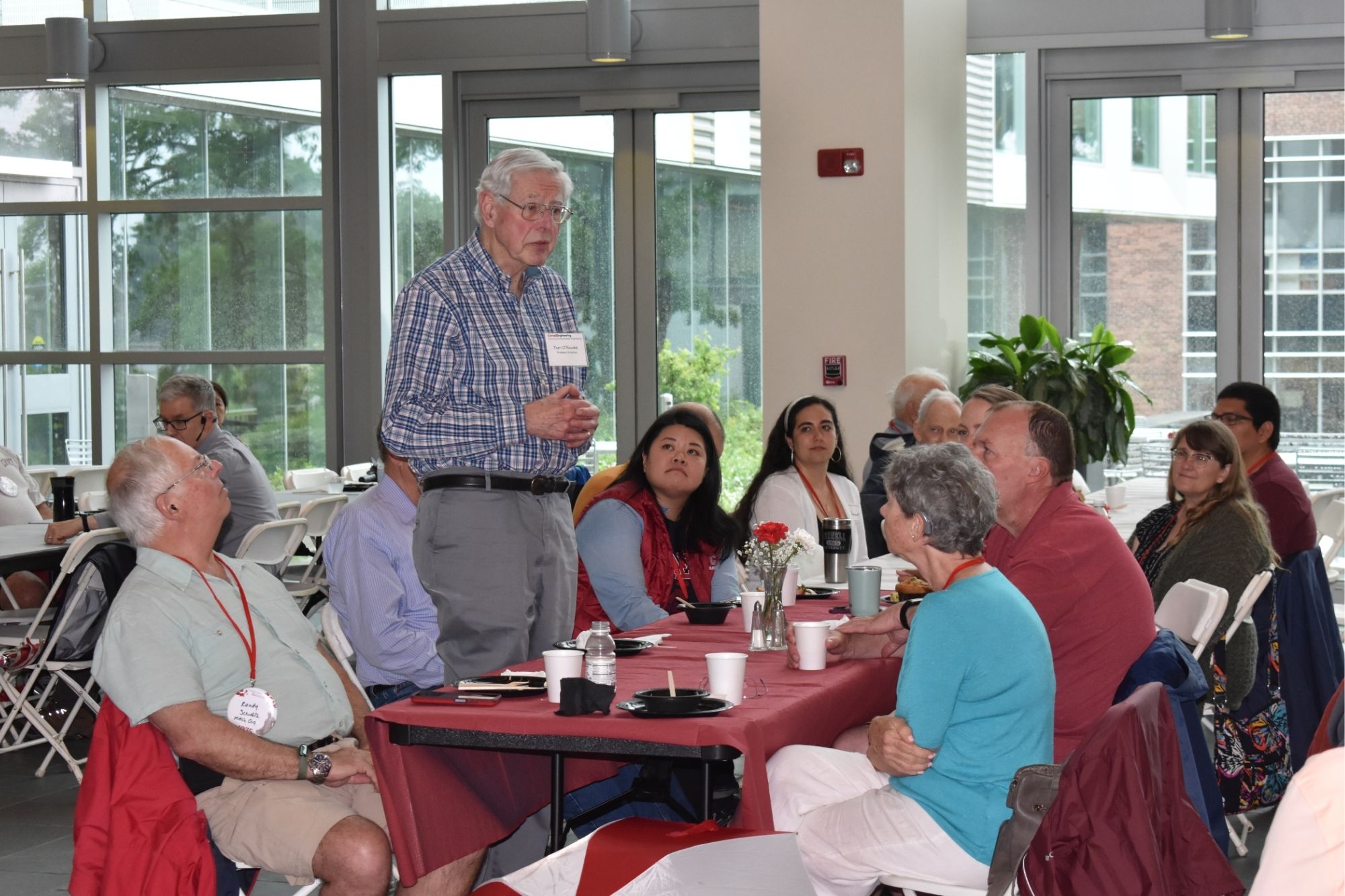 Several people sit around a table at the CEE Reunion with drinks.
