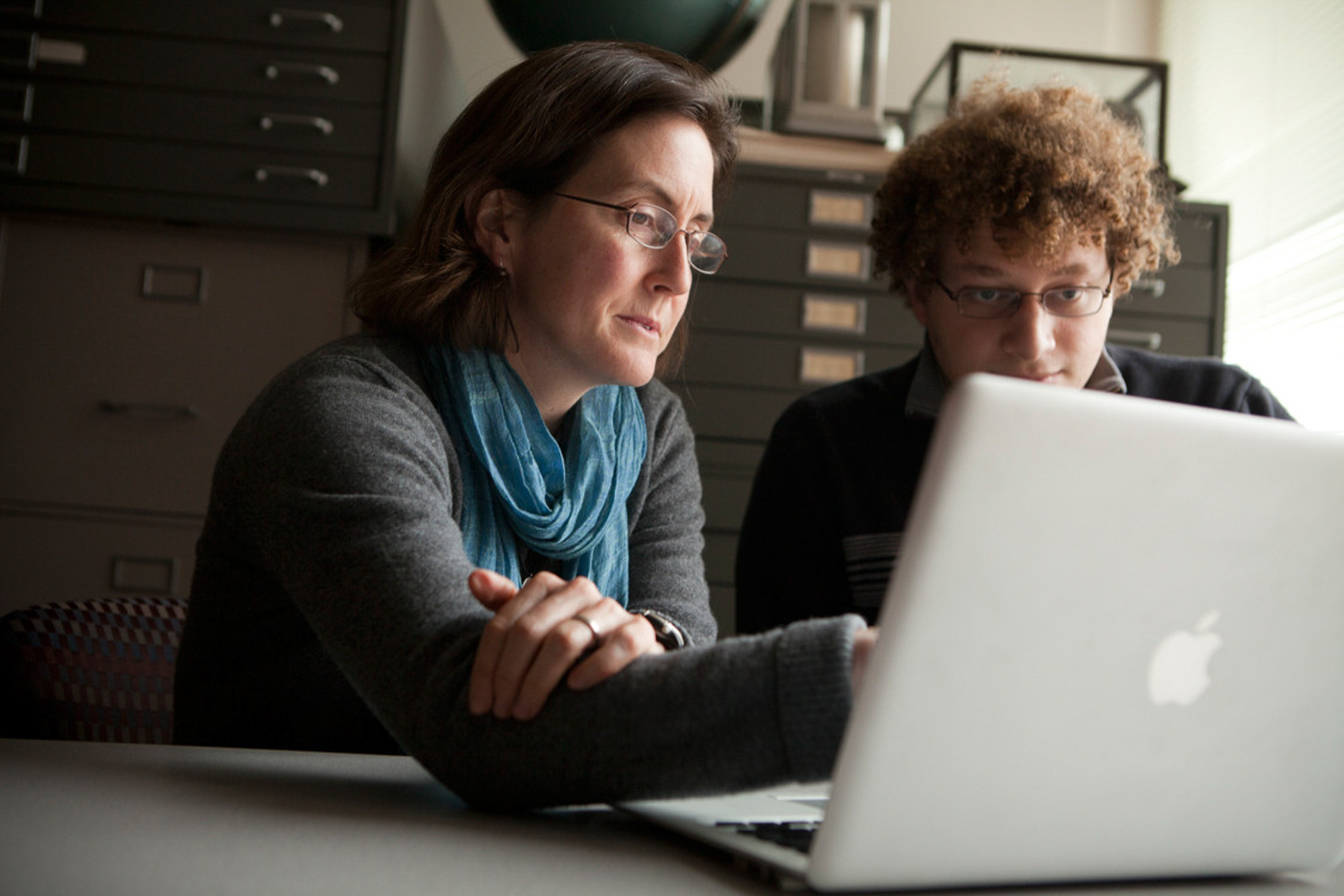Natalie Mahowald works with graduate student Daniel Ward at a laptop.