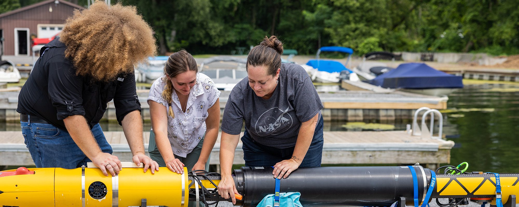 Students work with Britney Schmidt to prepare the icefin robot for tests in Cayuga Lake.