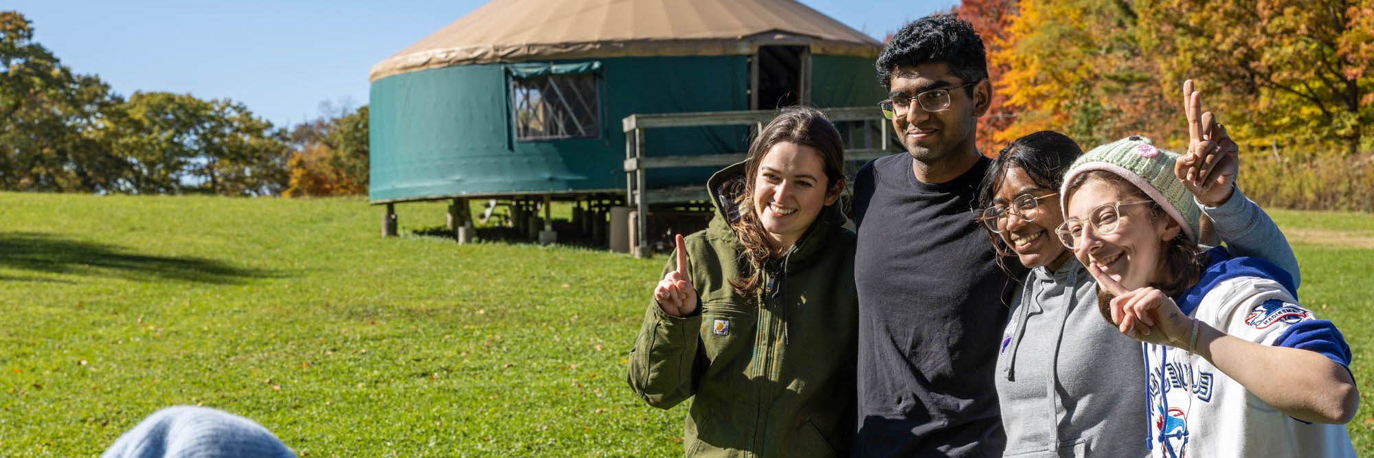 four students with arms around each other