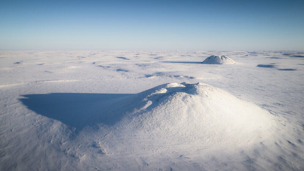 Ice-cored pingos emerge from permafrost and dot the arctic landscape near Tuktoyaktuk in northern Canada.