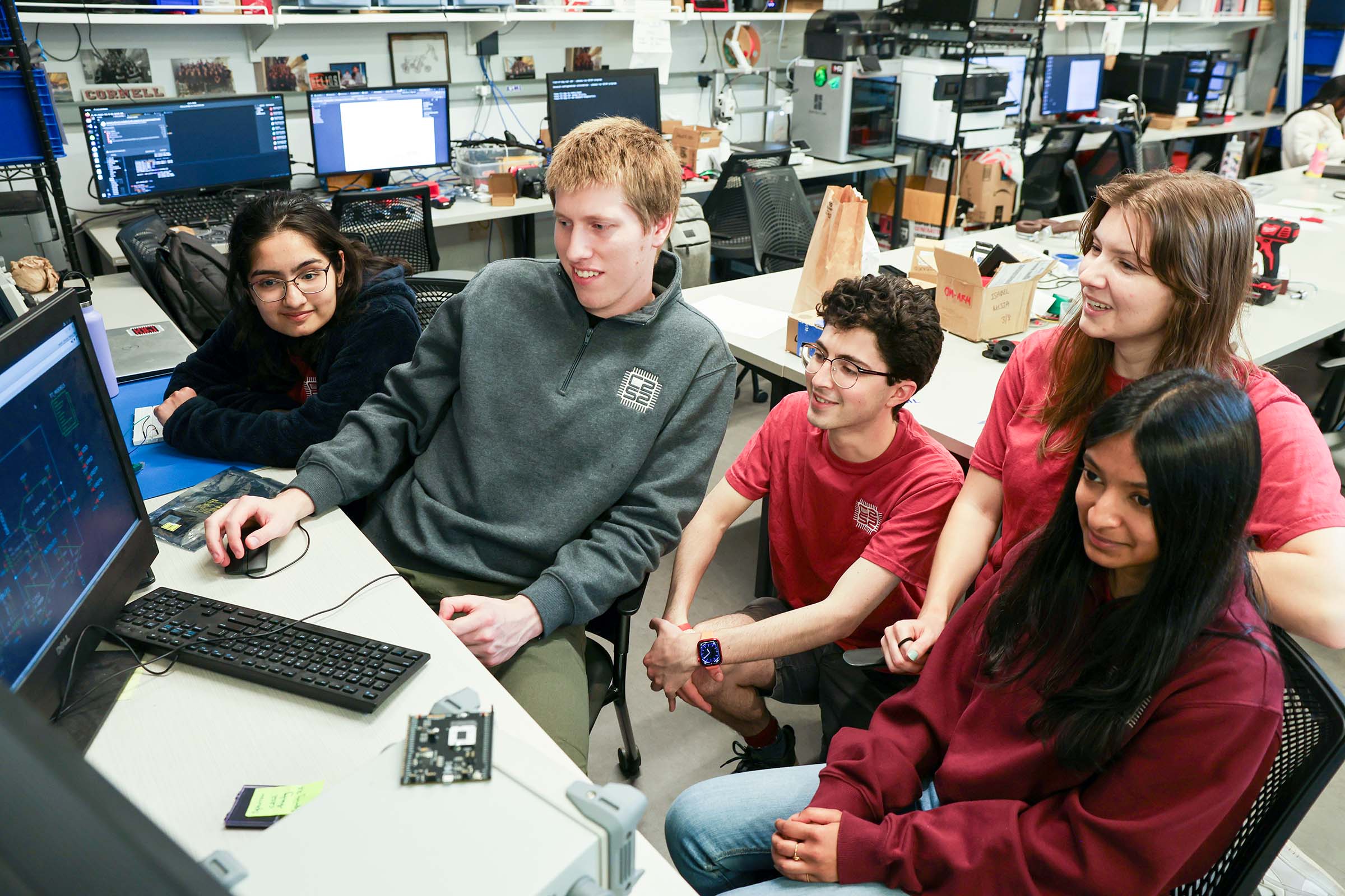 Members of the C2S2 lab run by Chris Batten looking at two monitors