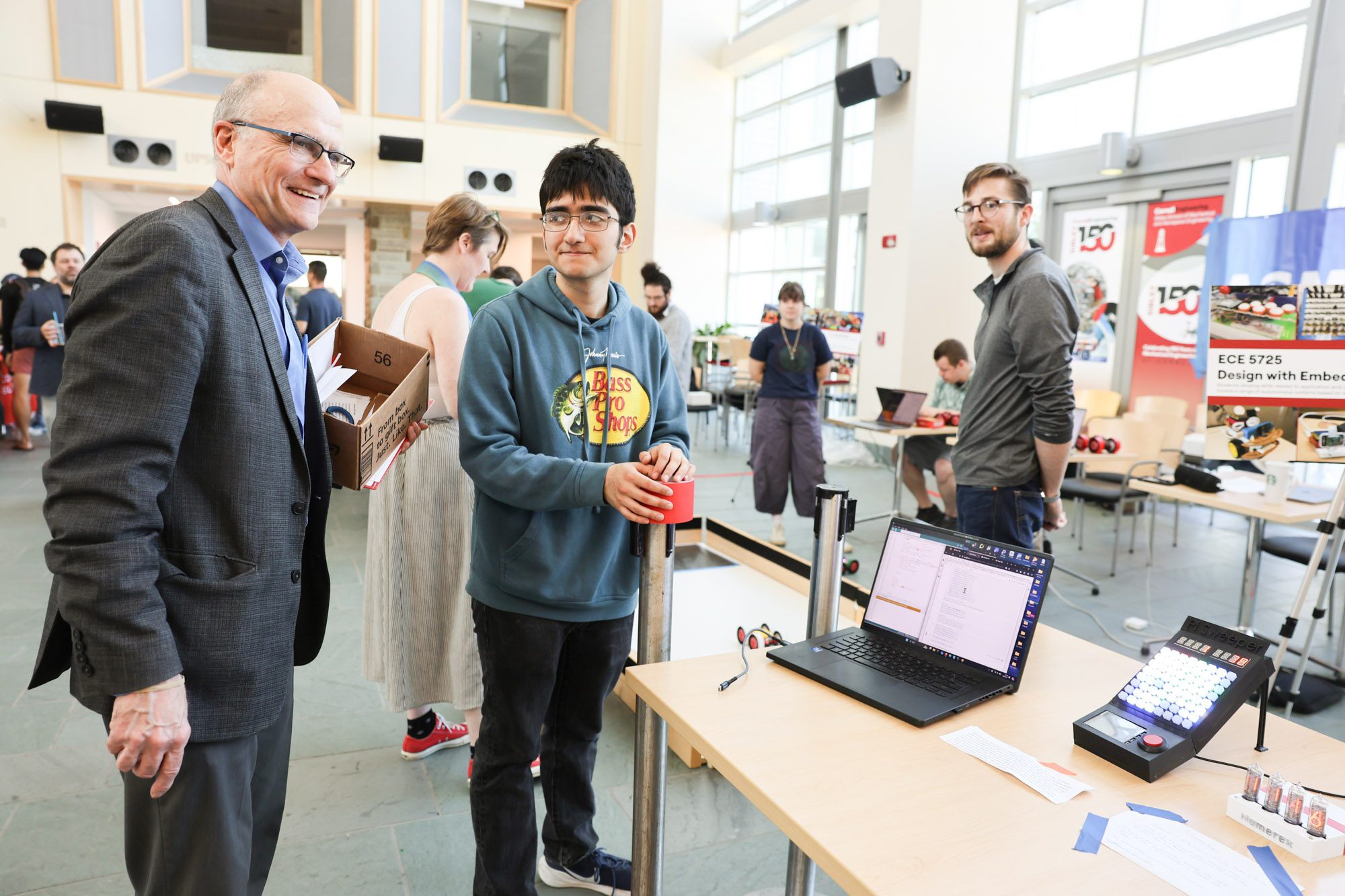 Joe Skovira talks to students during a robotics showcase