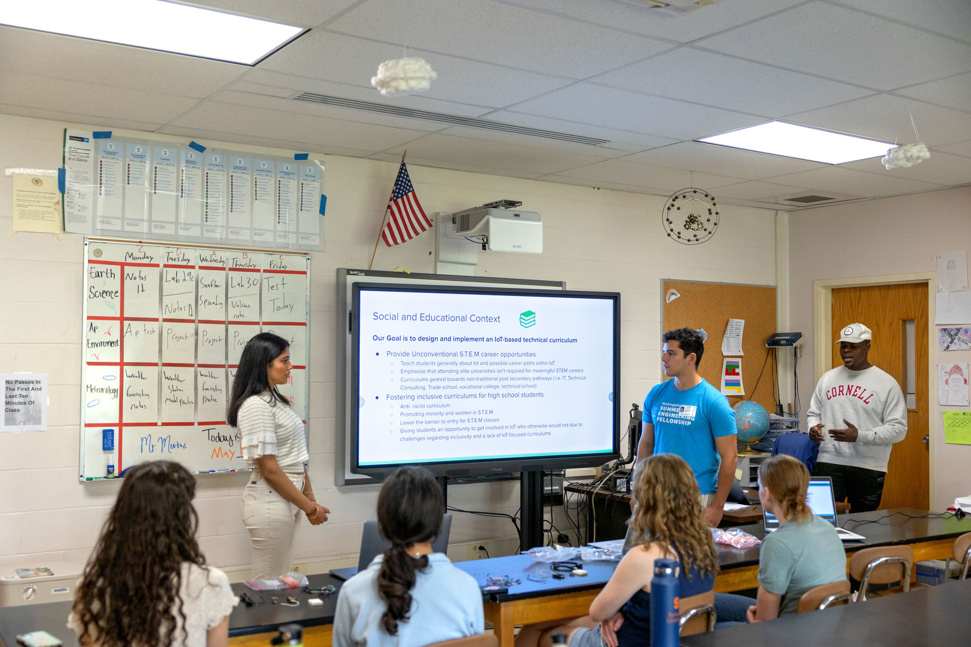 three students present to a classroom of other students, with the words 