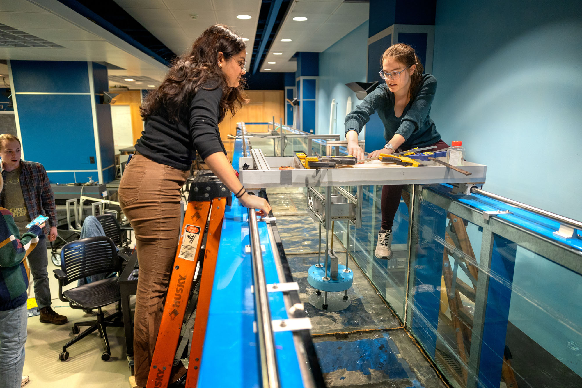 Kavya Mittha and Aisha Brundan test their wave energy conversion machine in the wave simulator tank in Hollister Hall.