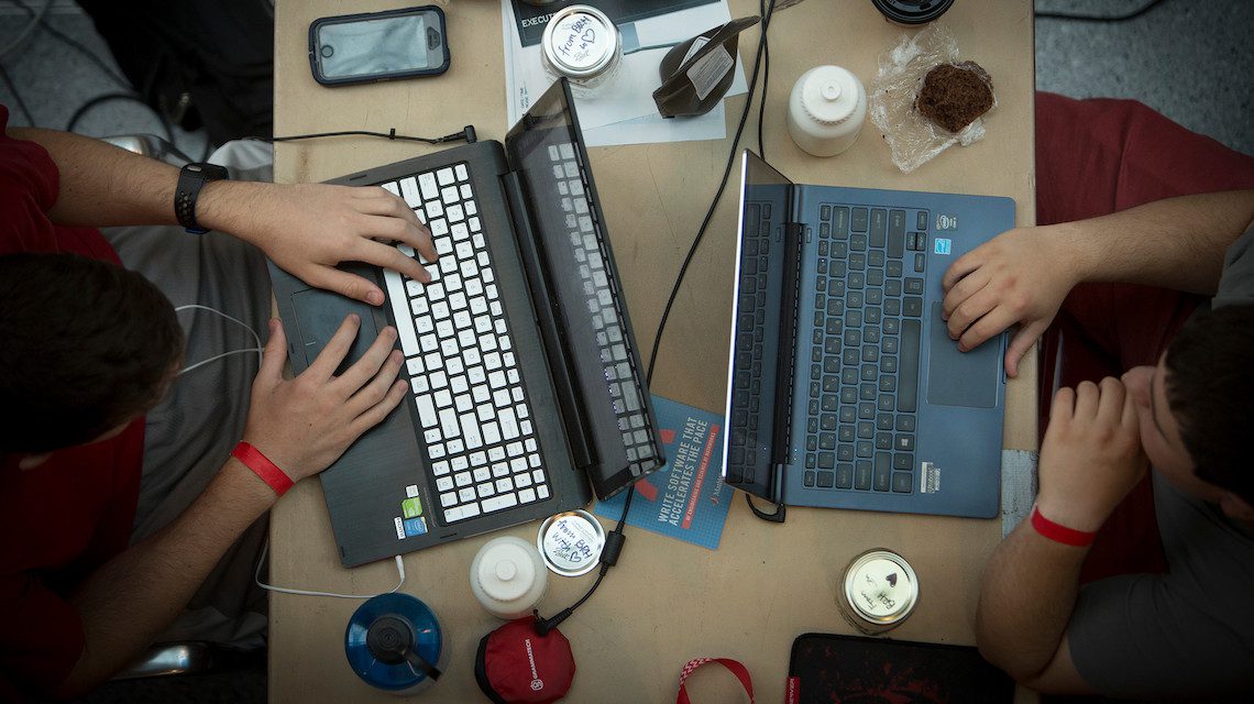 hands type of two laptops seen from above