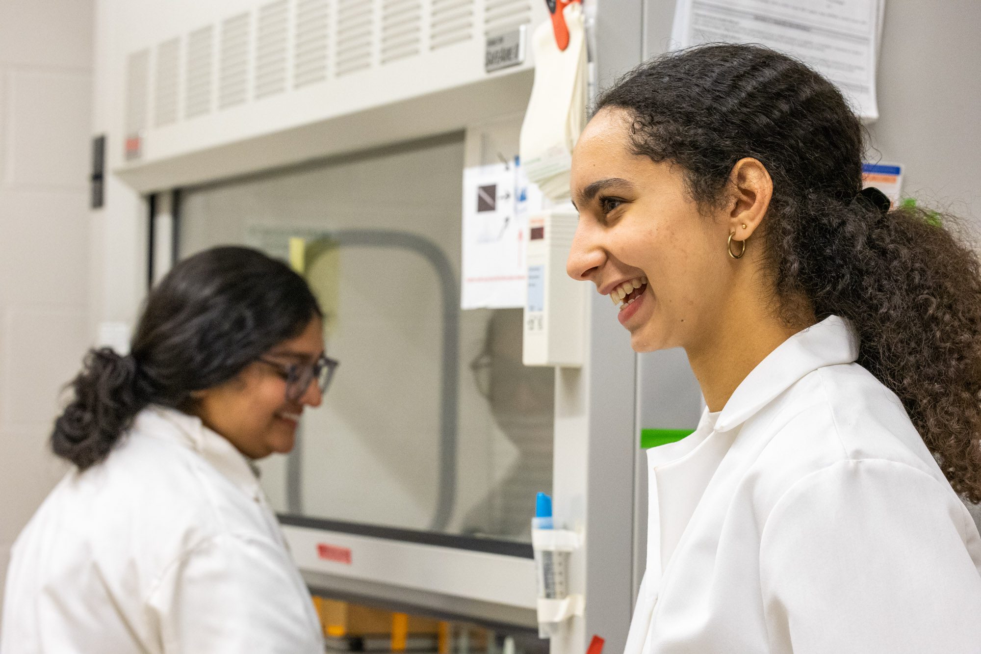 Asher and Zaina smile while working in the lab