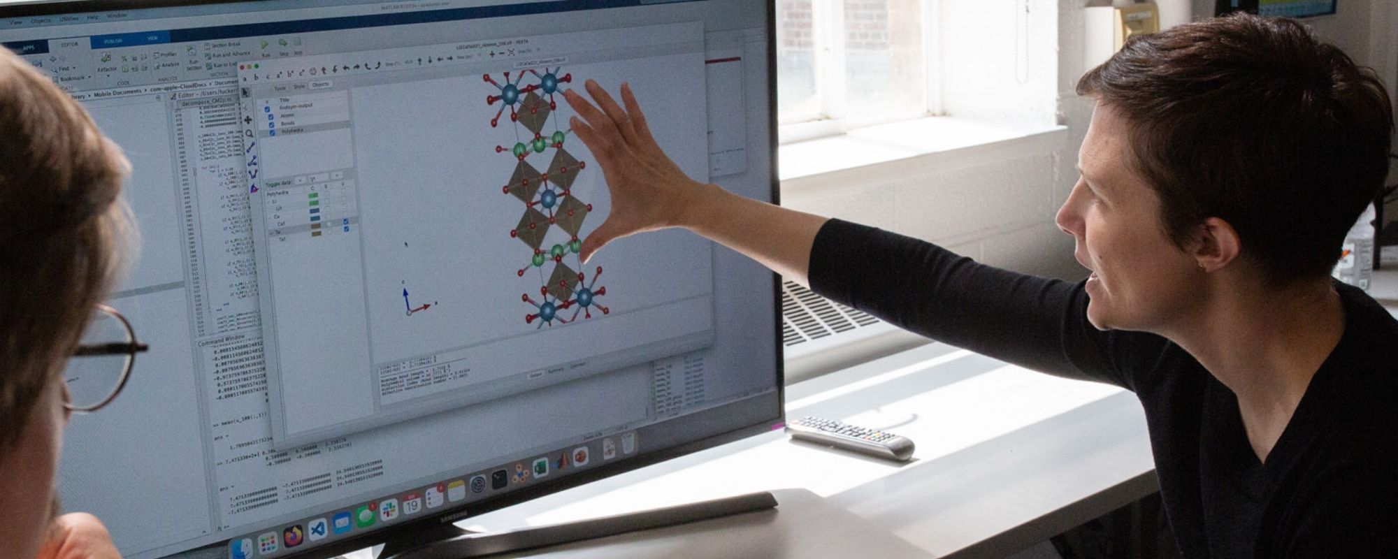 Associate professor Nicole Benedek and a graduate student looking at a computer monitor in her office