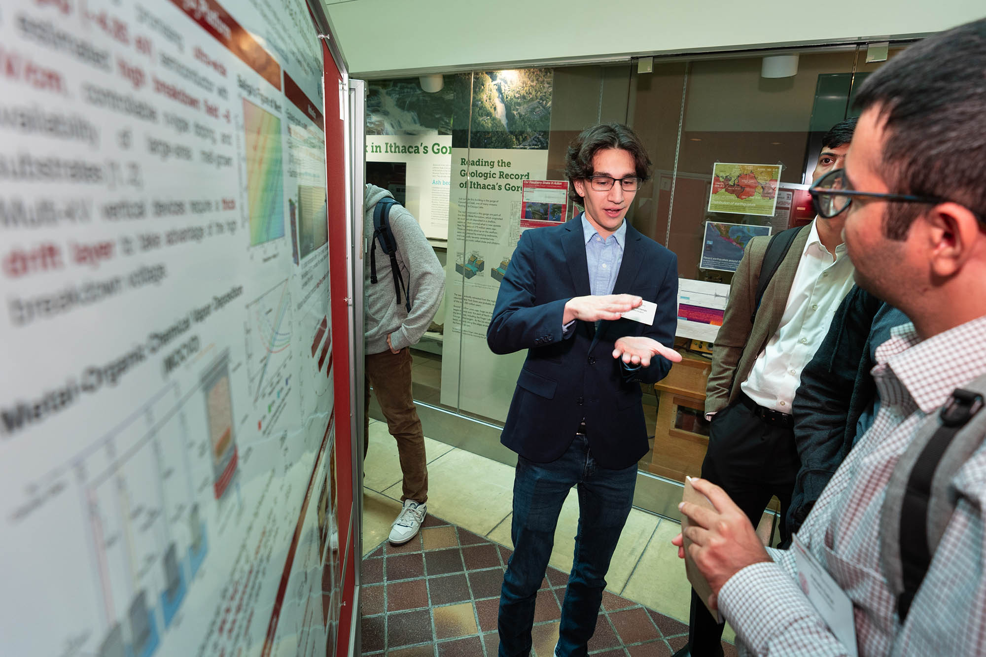 Student presenting to a group in front of a poster board