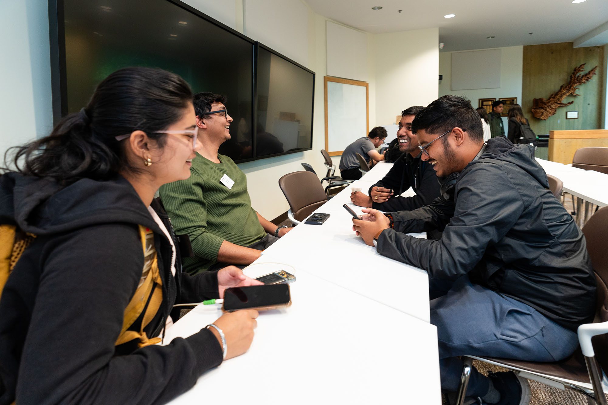 Group of students laughing around a table