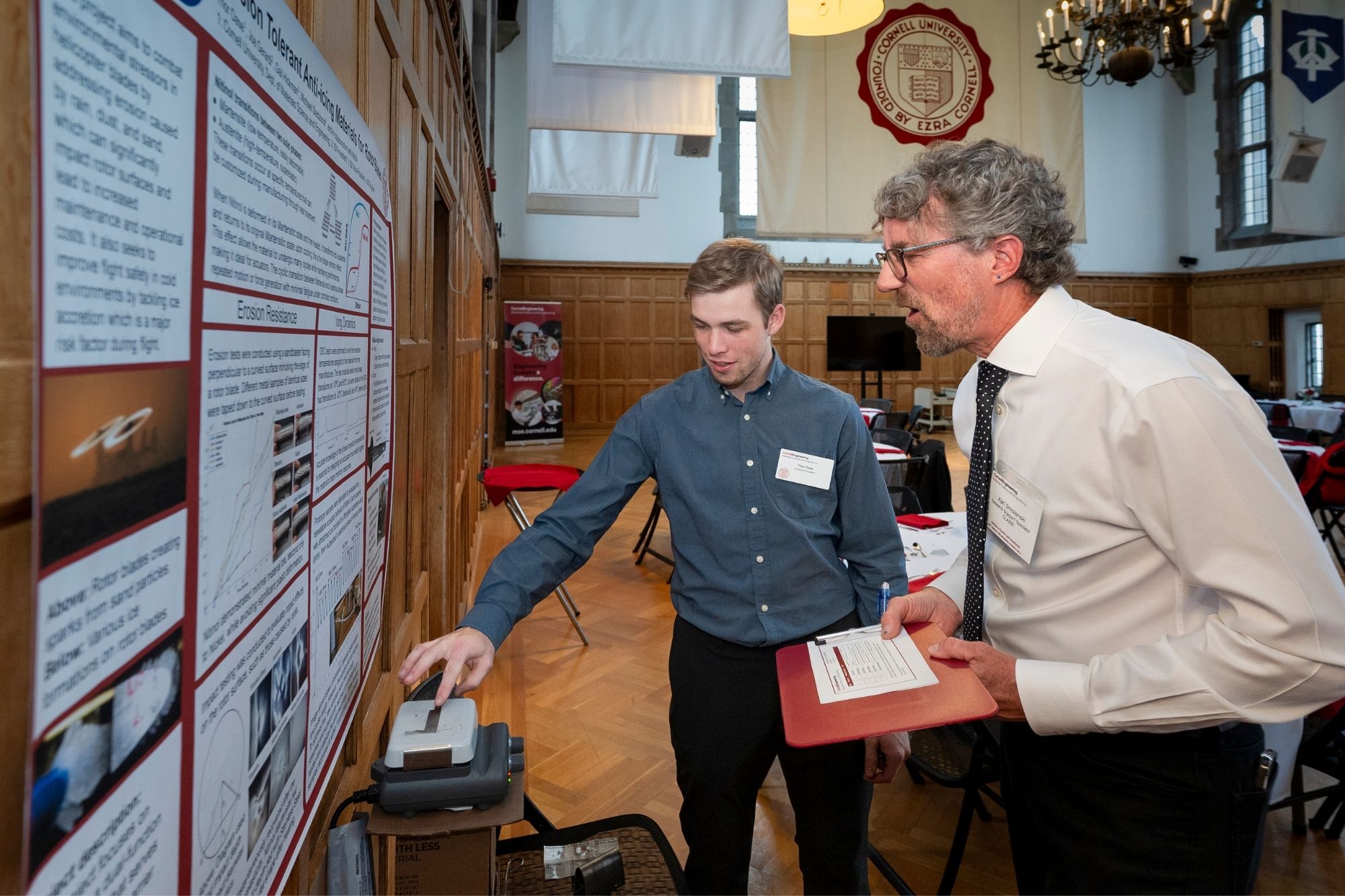 Thor Oase discusses his research during a poster session to industry partners