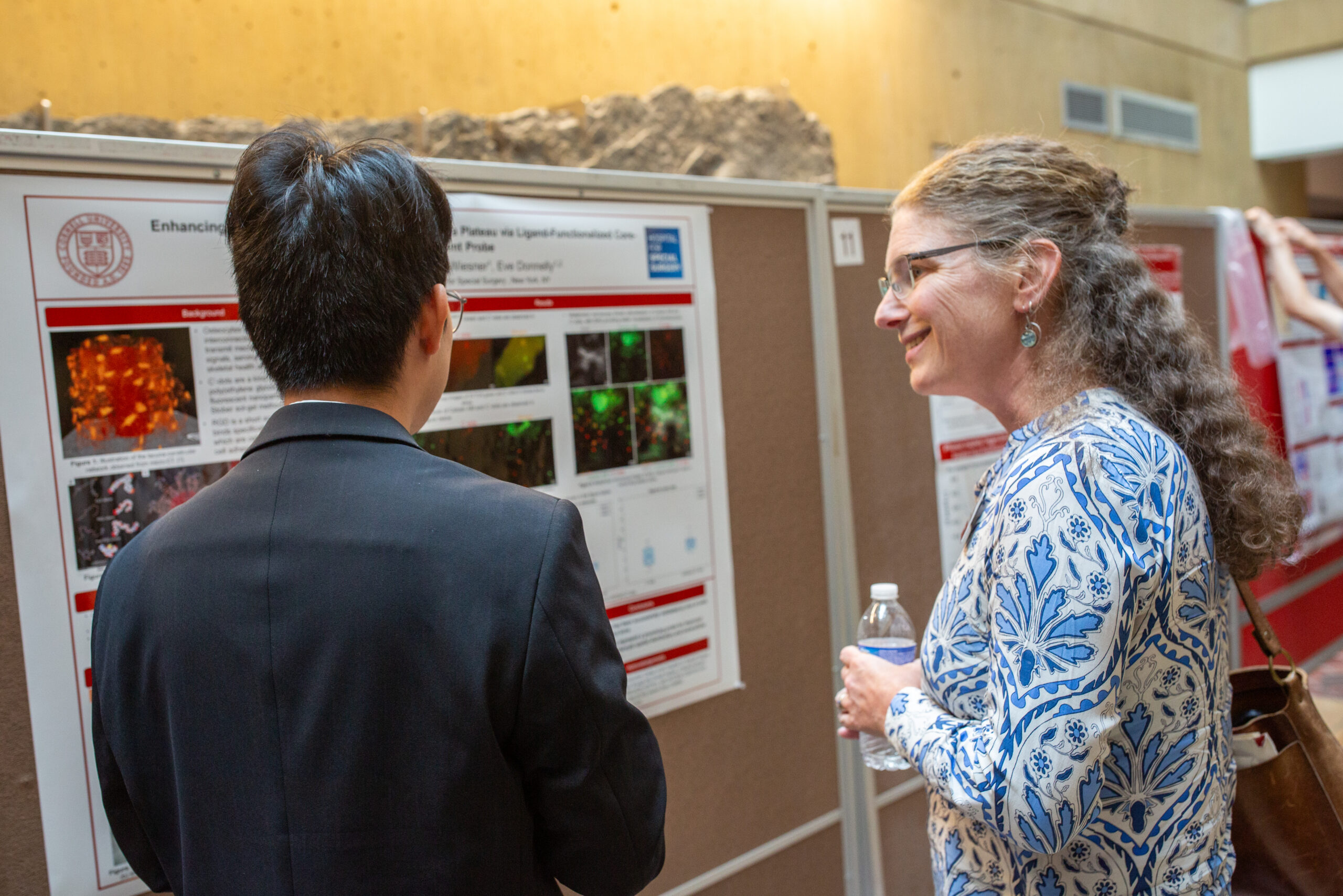 Lara Estroff talking to a student during a poster session