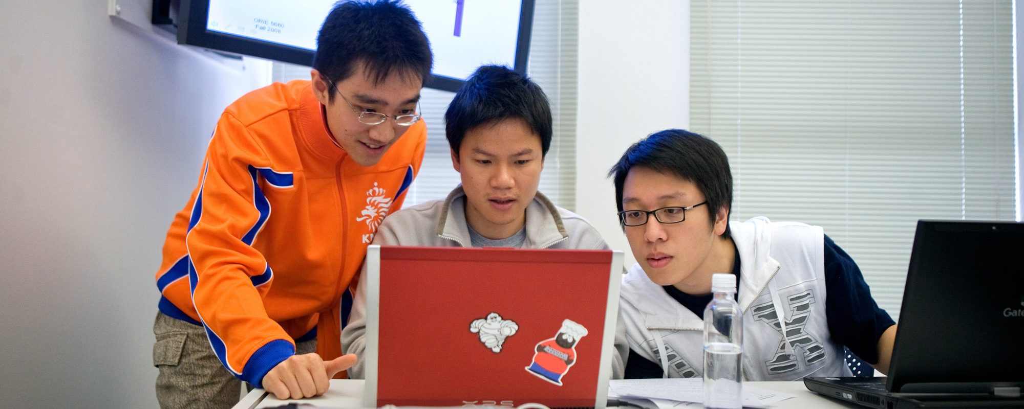 Three students working together on a laptop
