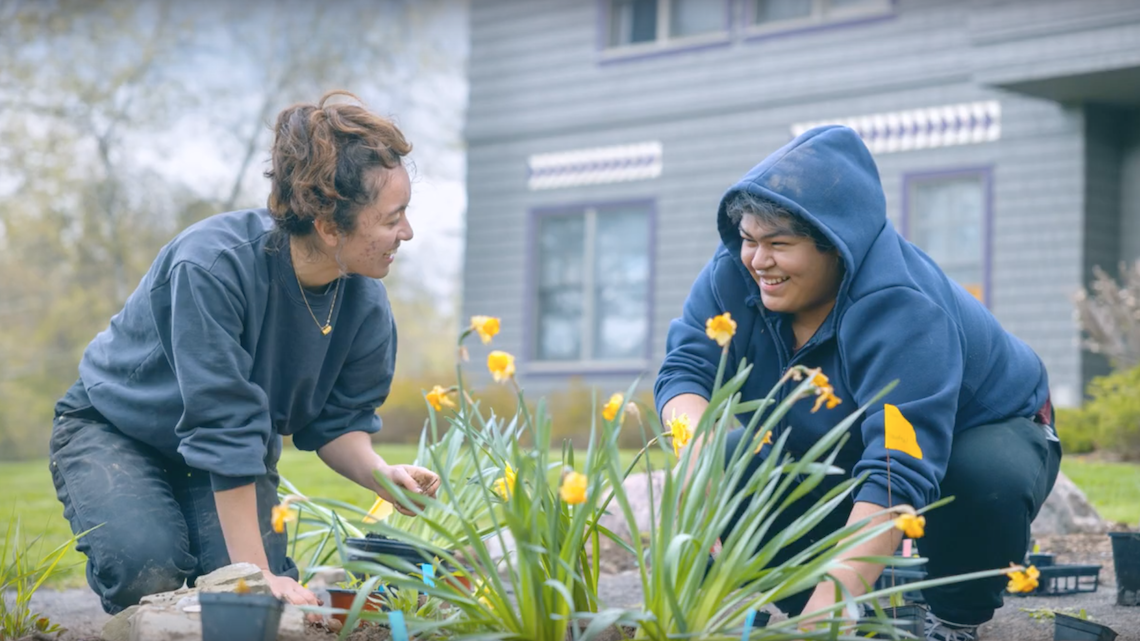 two students plant flowers