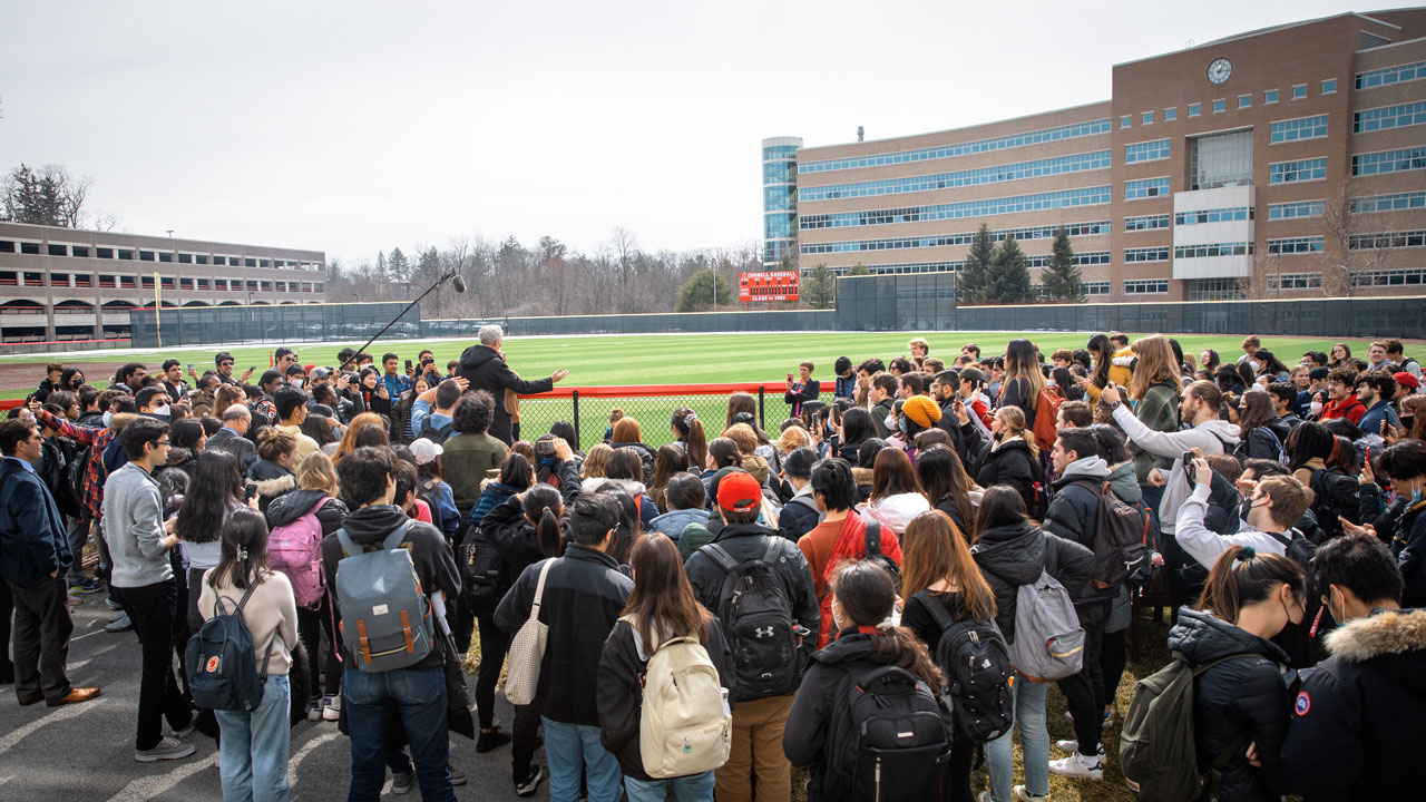 Bill Nye with student crowd looking across Hoy Field to Rhodes Hall and the Bill Nye Solar Noon Clock