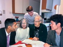 From left, Cornell master’s student Eric Bachoo; building resident Lisa Harrison; Tom Sahagian, an energy-efficiency consultant and co-manager of the heat pump project; Cornell master’s student Daniel Liang; and doctoral student Zach Lee, standing, pore over the new heat pump plans for the Upper West Side apartment building.