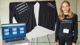 student stands next to computer