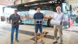 From left, Zach Reed, a mechanic with Transportation and Delivery Services, Christopher Kartawira ’21 and Mark Hurwitz, chief research compliance officer, hold components of the air filtration system that has enabled the C2C buses to resume service.