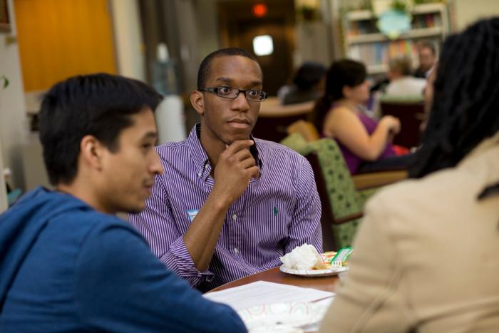 Student listening to others at a table