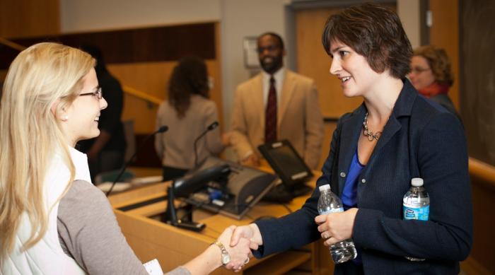 student shaking hands at an alumni event