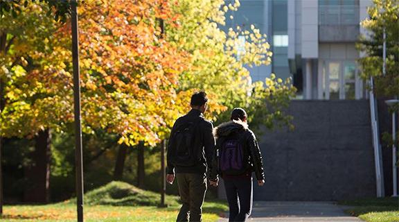 Two students walking on quad