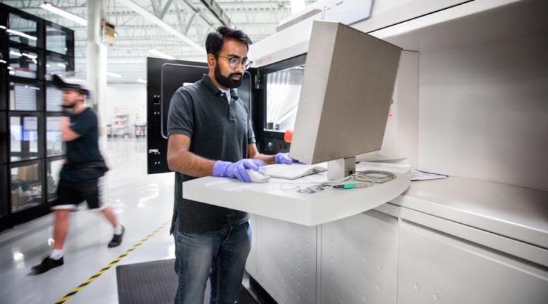 Ajay Krishnan sets up a metal 3-D printing machine for a job at Incodema3D