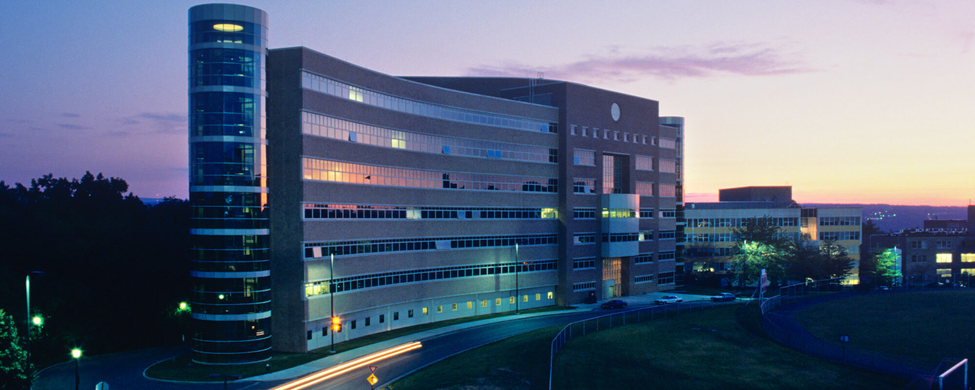 The moon rises over Rhodes Hall at dusk