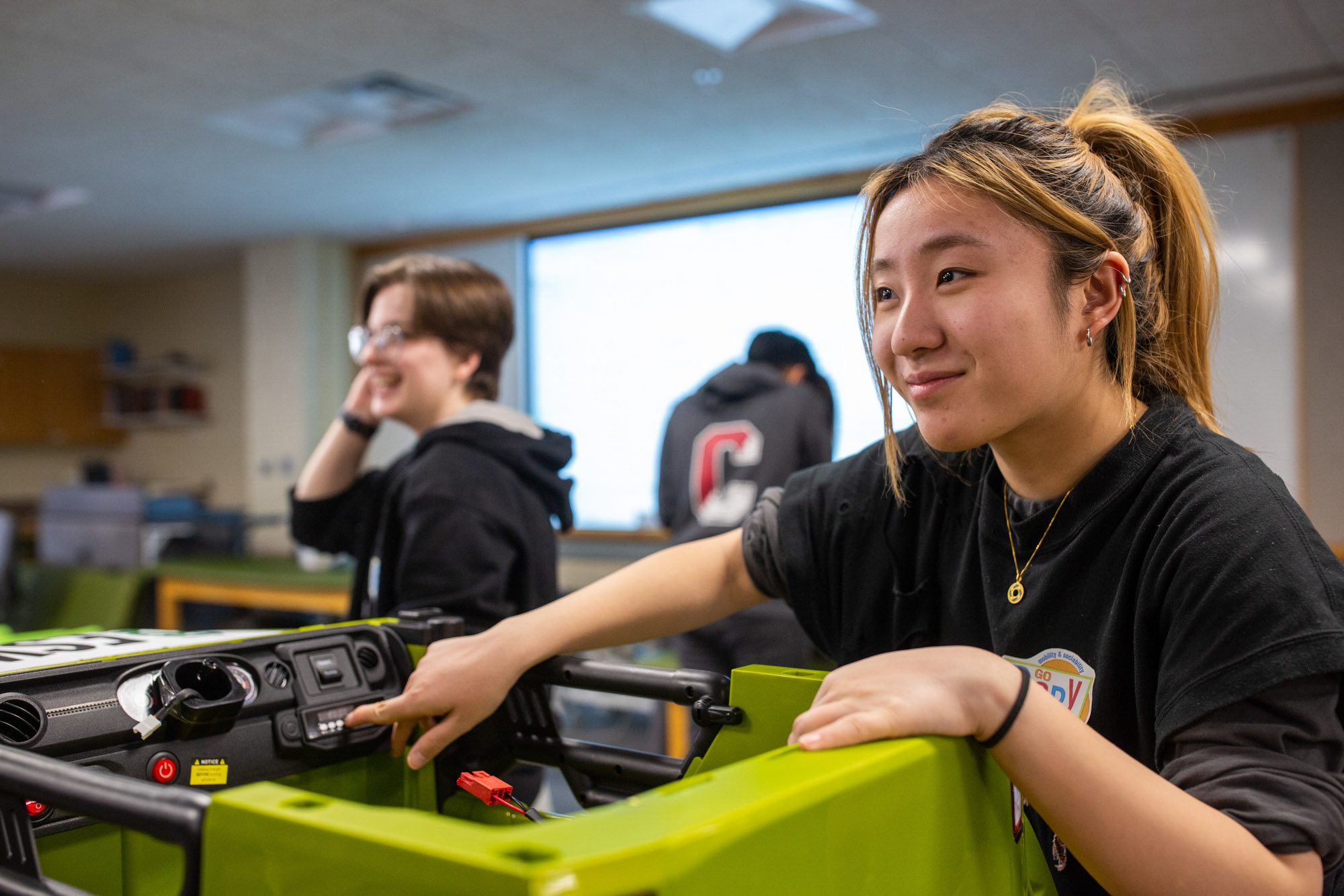 Big Red Adaptive Play and Design Initiative club member presses button on vehicle prototype.