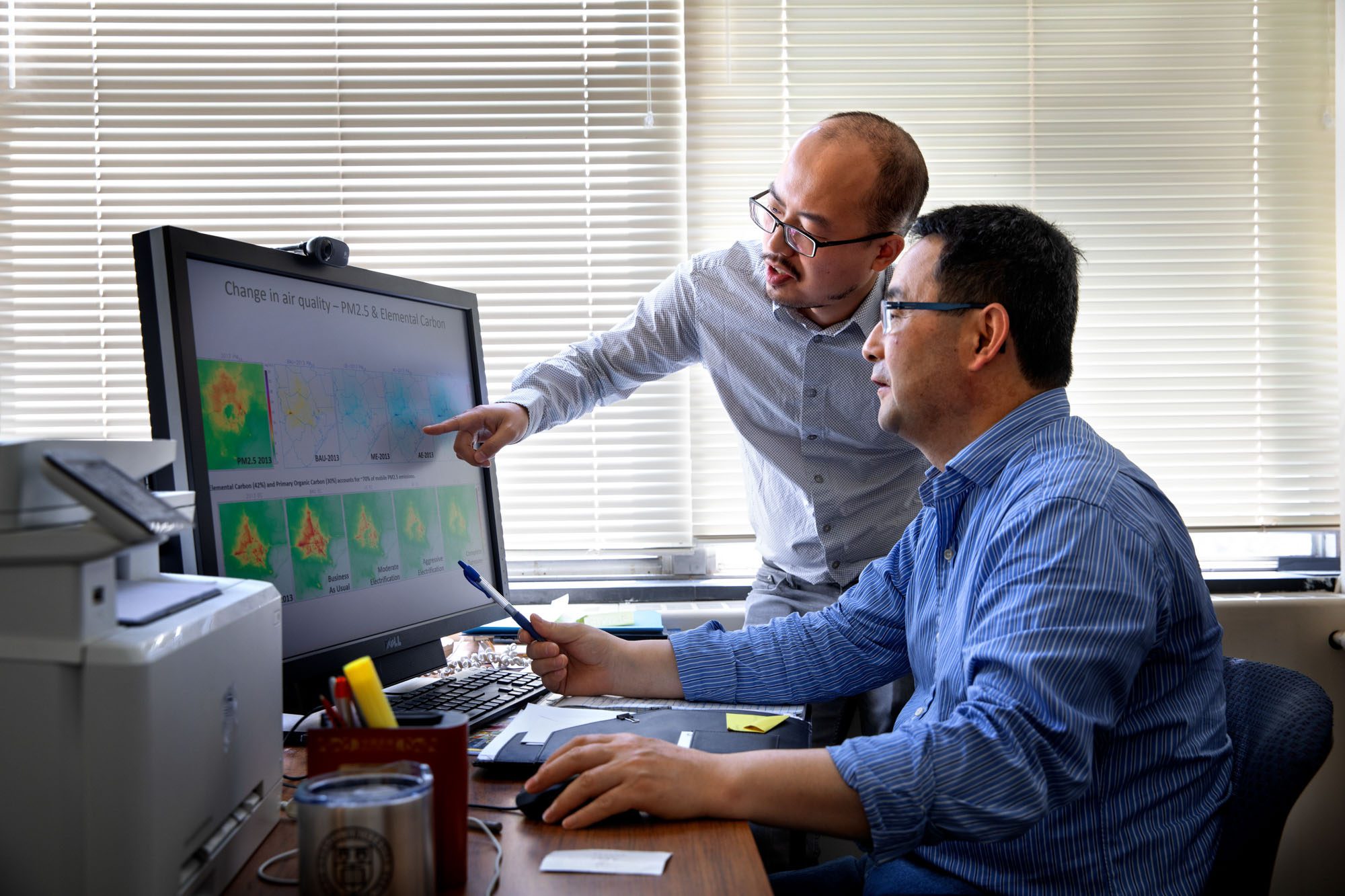 Professor Oliver Gao and Shuai Pan look at computer display